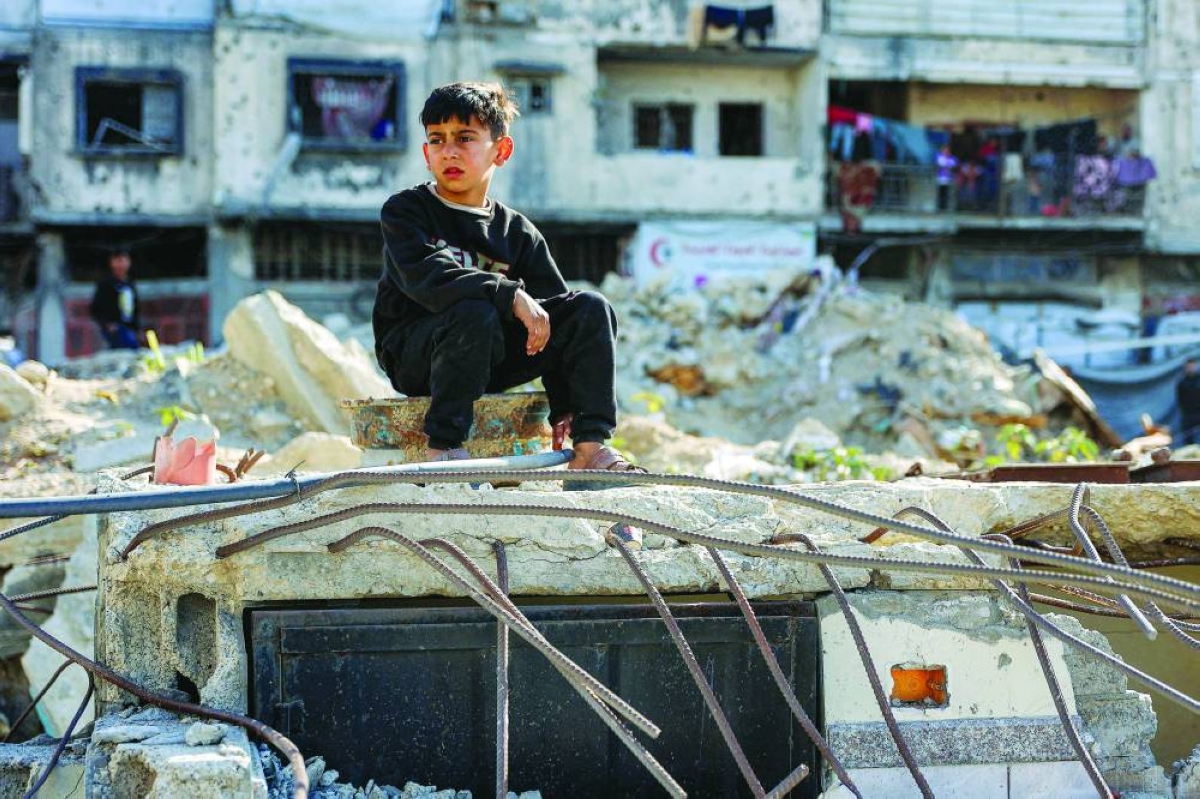 A boy looks on as he sits on rubble at the site of an Israeli strike on a police station in Gaza City on May 5, 2026. (AFP)