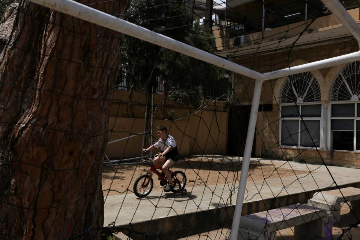 FILE PHOTO: A child rides a bicycle in Hariri High School II, used as a temporary shelter for displaced people, in Beirut, Lebanon, May 2, 2026. REUTERS/ Raghed Waked/File Photo