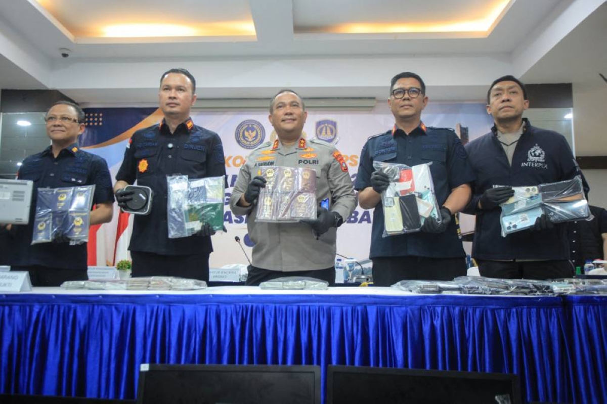 Officials and an Interpol representative in Indonesia display evidence seized during an immigration surveillance operation at the Batam Immigration Office in Batam in Riau Islands Province on Friday. (AFP)