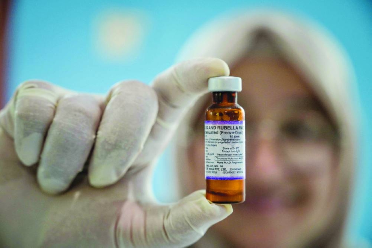 A health worker holding a measles-rubella vaccine in Surabaya, Indonesia.(AFP)