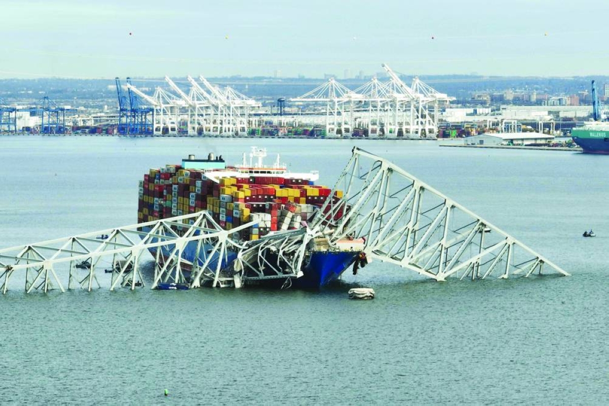 In this aerial image, the steel frame of the Francis Scott Key Bridge sits on top of a container ship after the bridge collapsed, Baltimore, Maryland, on March 26, 2024. A Singapore-based company and another in India have been indicted on multiple criminal charges over a 2024 ship crash that destroyed a bridge in the US state of Maryland and left six people dead, officials said on May 12, 2026. Synergy Marine Pte Ltd, based in Singapore, and Synergy Maritime Pte Ltd, based in Chennai, India, are accused of conspiracy to defraud, making false statements and other counts in connection with the collision of the vessel M/V Dali with the Francis Scott Key Bridge. (AFP/File picture)