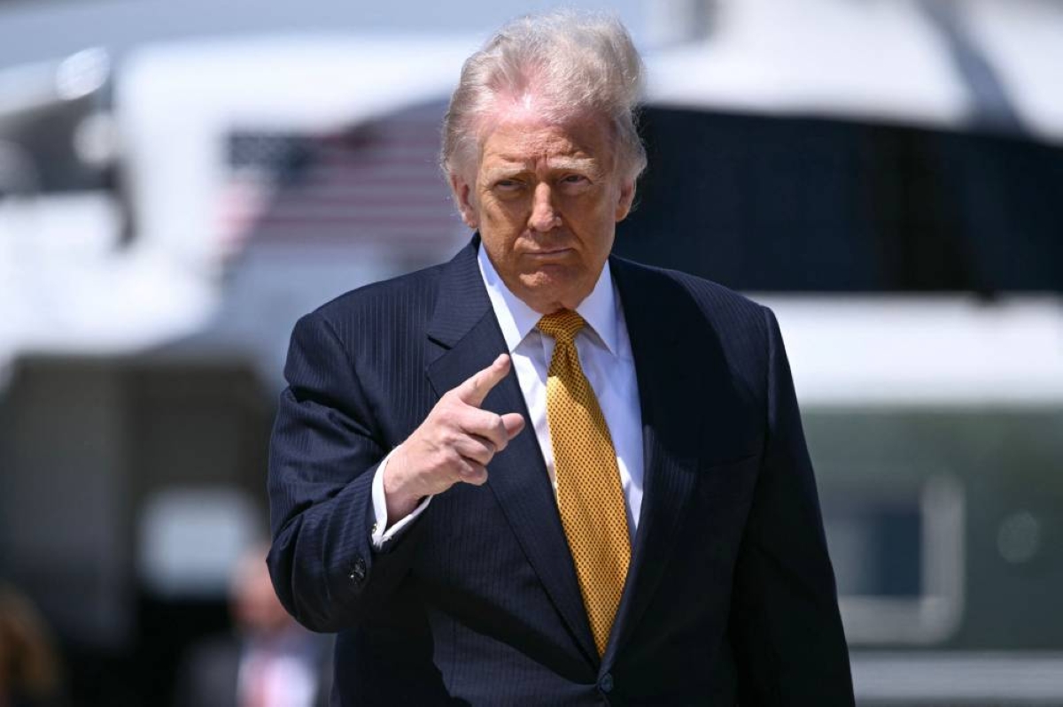 TOPSHOT - US President Donald Trump gestures prior boarding Air Force One at Joint Base Andrews, Maryland, on May 12, 2026 as he departs for a 3-day state visit to China. President Trump said Monday he was ready to discuss US arms sales to Taiwan during his visit this week to Beijing, as he suggested his personal chemistry with counterpart Xi Jinping would prevent a Chinese invasion of the island. Trump will bring along top US executives for a trip expected to focus heavily on the US president's hopes to ramp up trade. (Photo by Brendan SMIALOWSKI / AFP)