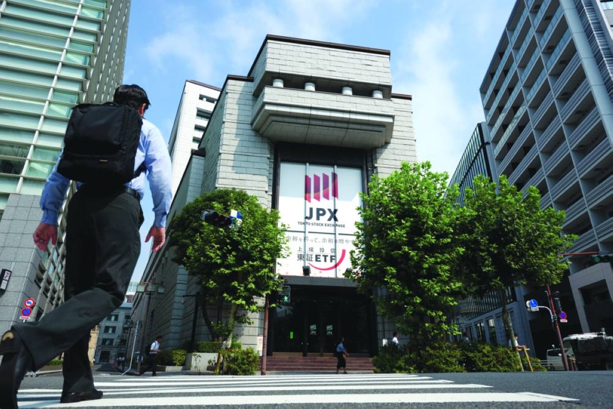 A pedestrian crosses the road in front of the Tokyo Stock Exchange. The Nikkei 225 closed down 1.0% to 62,654.05 points Thursday.