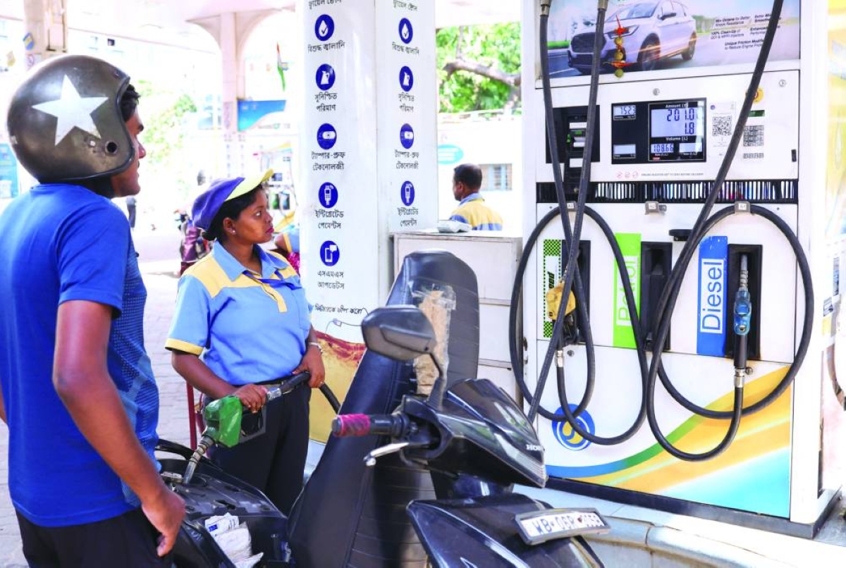 A worker pumps fuel into a motorcycle as newly increased fuel prices are displayed at a fuel station in Kolkata, yesterday. (Reuters)
