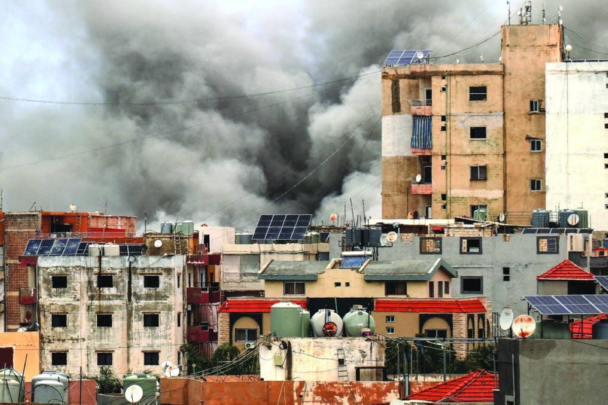Smoke rises behind buildings following an Israeli airstrike in the southern city of Tyre yesterday. – AFP