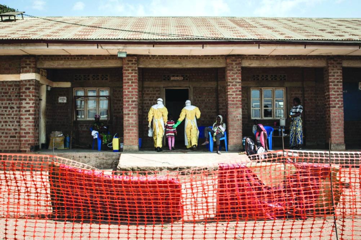This picture taken in 2018 shows medical workers leading a girl with suspected Ebola into the unconfirmed Ebola patients ward run by The Alliance for International Medical Action (ALIMA) in Beni, northeastern Democratic Republic of the Congo. – AFP