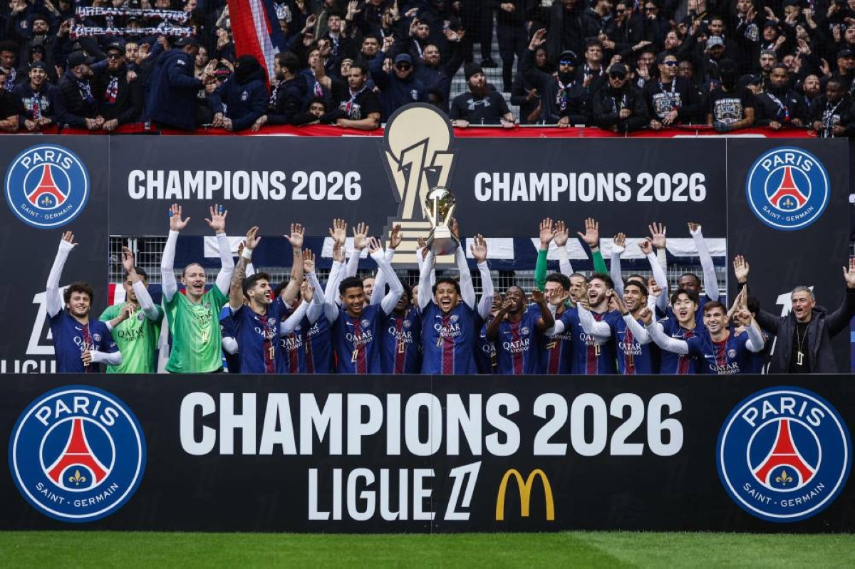 TOPSHOT - PSG players and Paris Saint-Germain's Spanish head coach Luis Enrique (R) celebrate with the French Ligue 1 trophy after winning the championship ahead of the French L1 football match between Paris FC and Paris Saint-Germain (PSG) at the Stade Jean-Bouin in Paris on May 17, 2026. (Photo by Kenzo TRIBOUILLARD / AFP)
