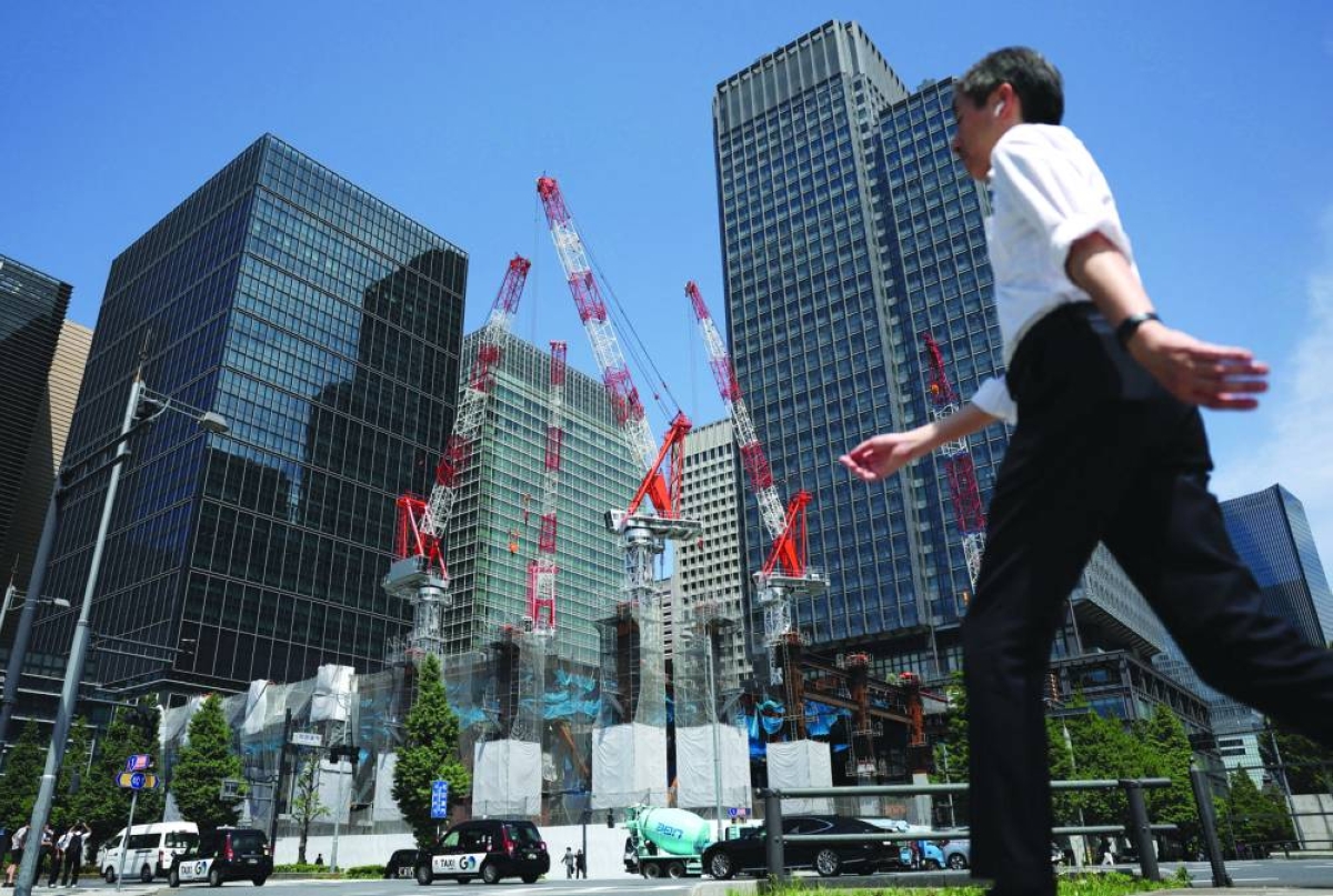 A man walks past on the street near a construction site in Tokyo. Japanese economic growth surpassed expectations at the start of 2026, official data showed Tuesday, but Prime Minister Sanae Takaichi is mulling an extra budget as concerns grow over inflation due to the Middle East war.