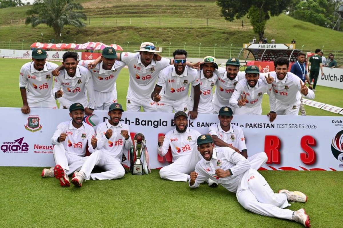 Bangladesh’s players pose with the tournament trophy after winning the second Test cricket match between Bangladesh and Pakistan at the Sylhet International Cricket Stadium in Sylhet on May 20, 2026. (AFP)