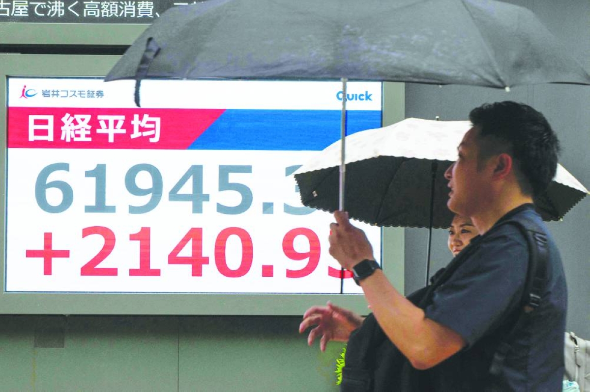 An electronic quotation board displays the Nikkei Stock Average on the Tokyo Stock Exchange along a street in Tokyo. The Nikkei 225 closed up 3.1% to 61,684.14 points Thursday.