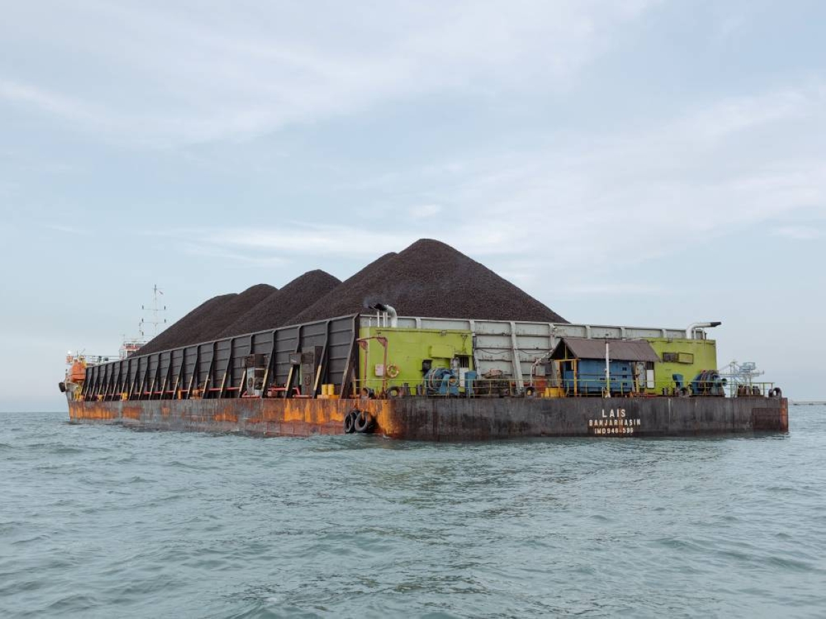 A barge of coal in West Java, Indonesia. For years, Indonesia’s raw materials have been ferried from remote mines and plantations to global markets by armies of traders who handle negotiations, loans and even cranes and river barges. Now the government is taking over, hoping to save billions of dollars it says are otherwise lost in transit.