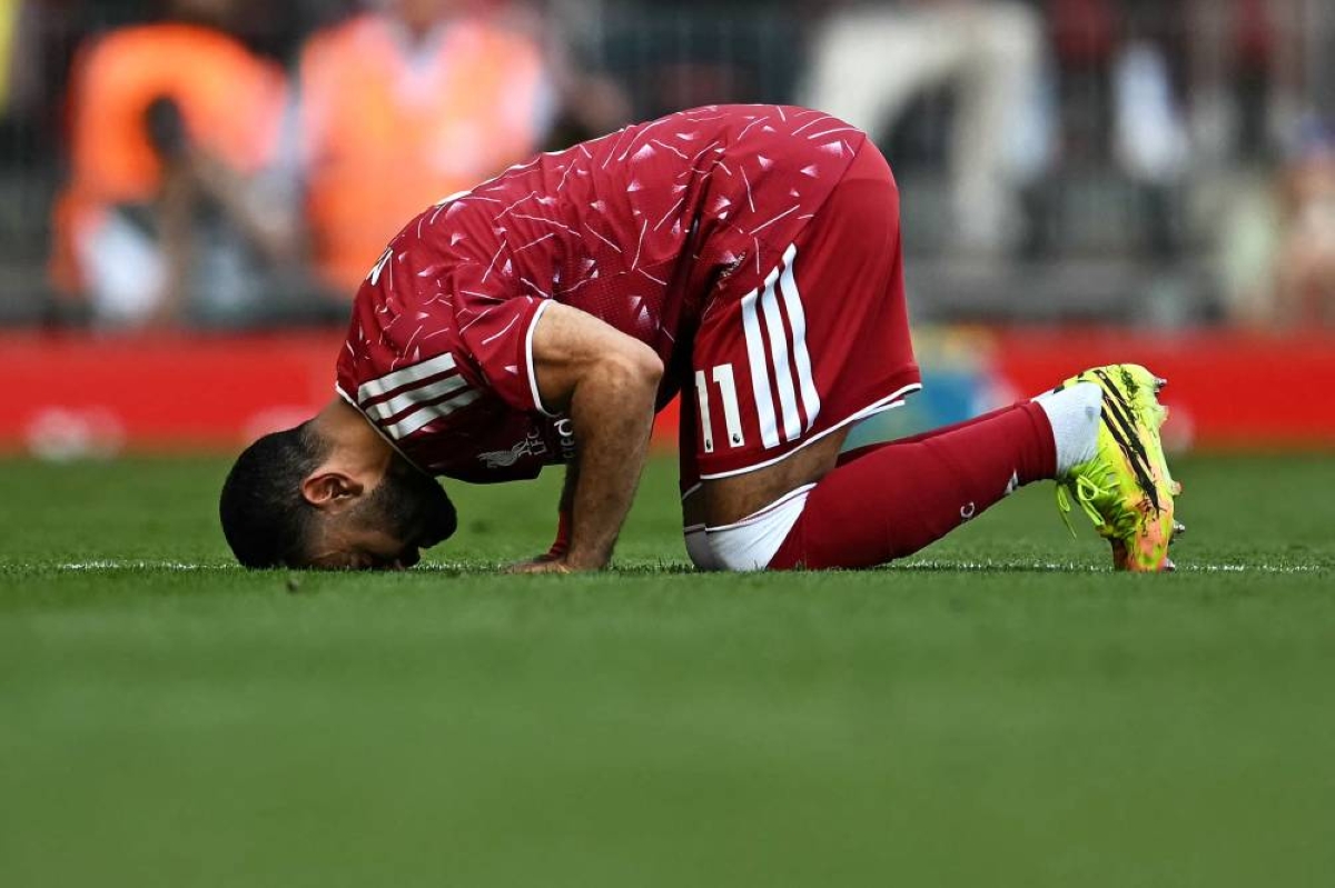 Liverpool's striker Mohamed Salah kisses the grass as he leaves the pitch after being substituted off during the Premier League match against Brentford at Anfield in Liverpool, north west England. (AFP)