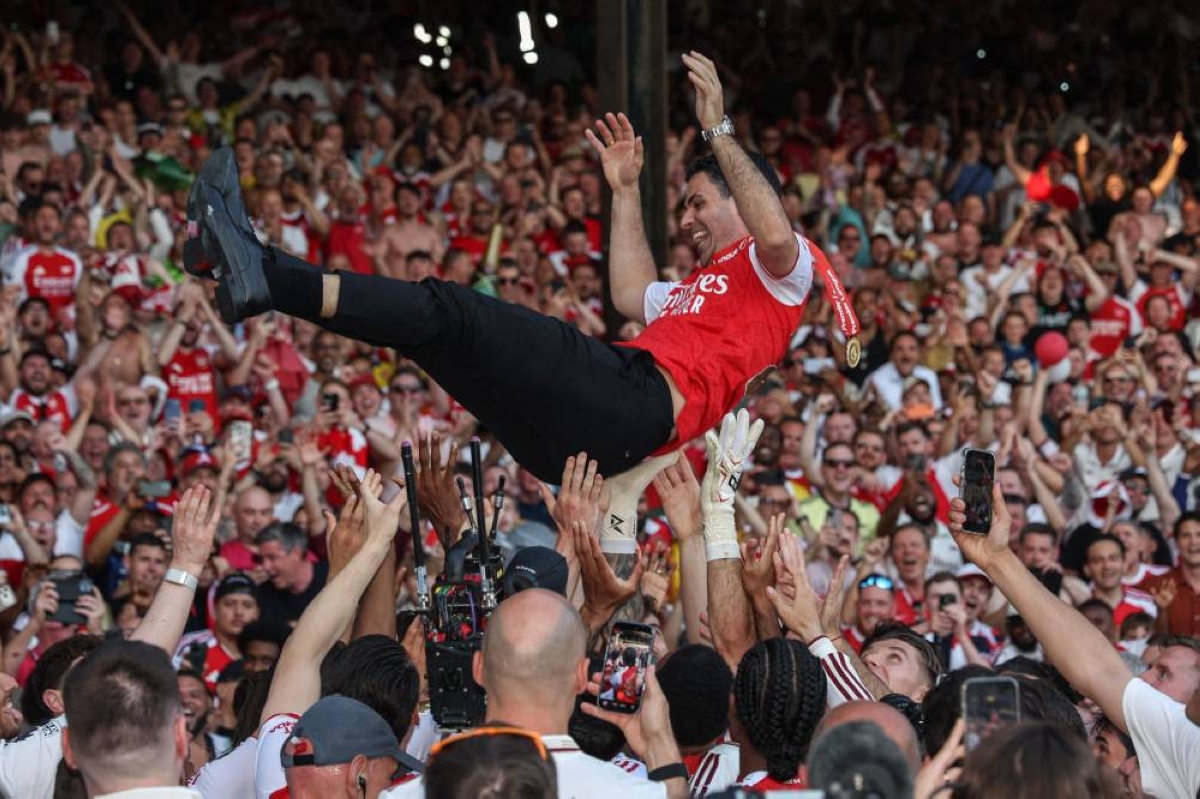 Arsenal's manager Mikel Arteta is thrown into the air by his players as they all celebrate after the Premier League trophy presentation at Selhurst Park in south London. (AFP)