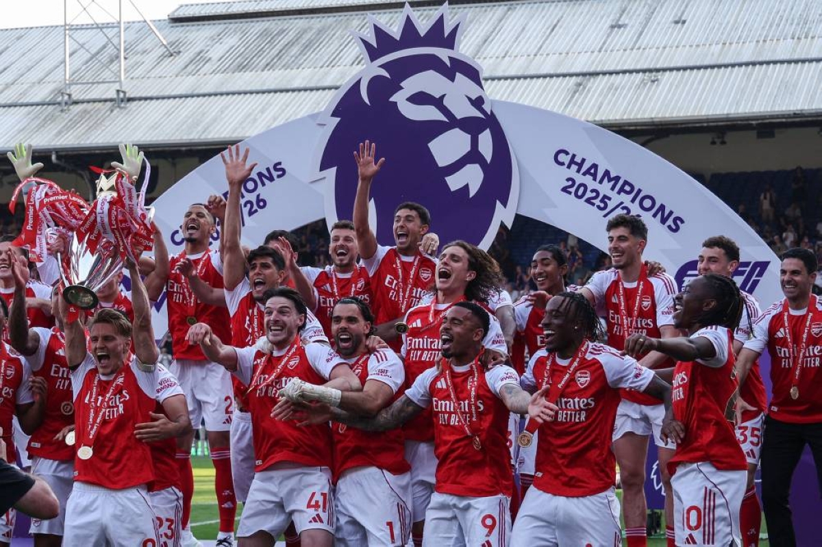 Arsenal's captain Martin Odegaard lifts the Premier League trophy as he celebrates with his teammates in London. (AFP)