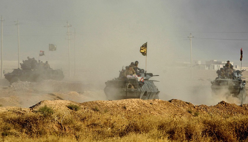 Iraqi forces drive their tanks in the area of al-Shourah