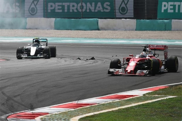 German driver Sebastian Vettel (right) damages his steering after clipping Nico Rosberg