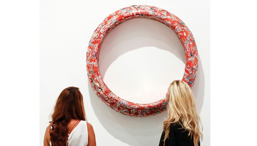 Two women watch the artwork \"TV less Ring\" by Spanish artist Antoni Miralda