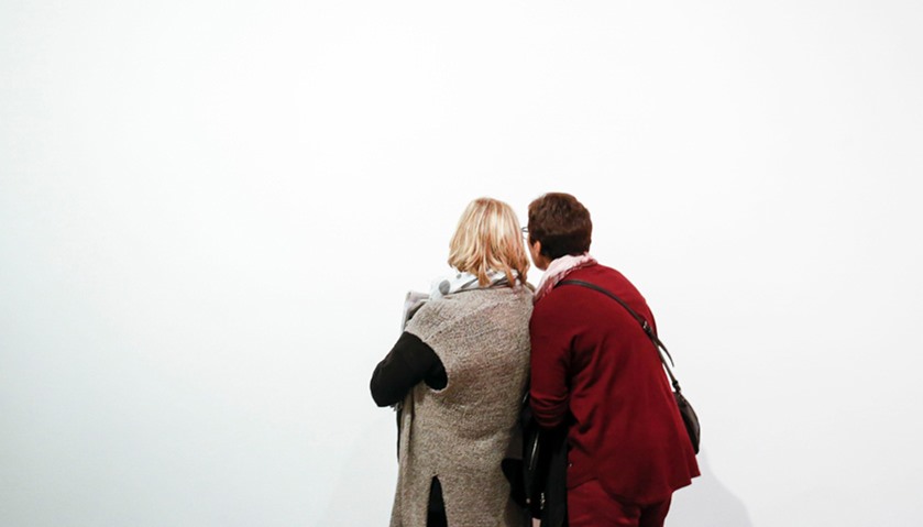 Two women read some information about an artwork