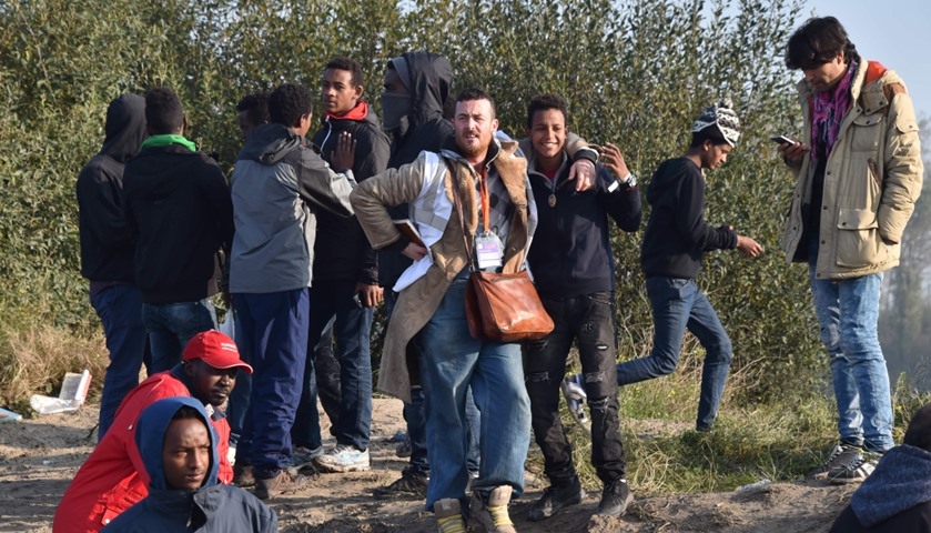 A volunteer (C,L) stands together with young migrants during the full evacuation