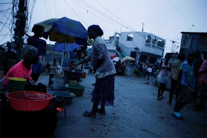 People buy goods on the street while Hurricane Matthew approaches Port-au-Prince