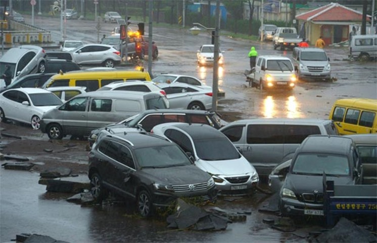 Cars damaged by flood waters are seen along a street in the southern island of Jeju on Wednesday
