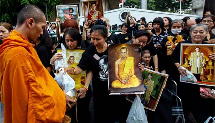 Thais offer alms to monks to mark the first anniversary of King Bhumibol Adulyadej\'s death