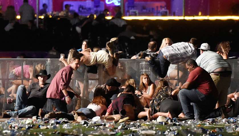 People scramble for shelter at the Route 91 Harvest country music festival after apparent gun fire w