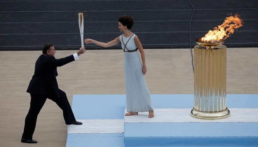 Katerina passes the flame to Spyros Capralos, President of Hellenic Olympic Committee
