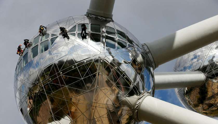 Workers rappel down along one of the nine spheres of the Atomium