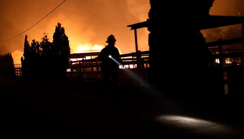 A firefighter runs along a dirt road during the wind-driven Kincade Fire in Windsor, California