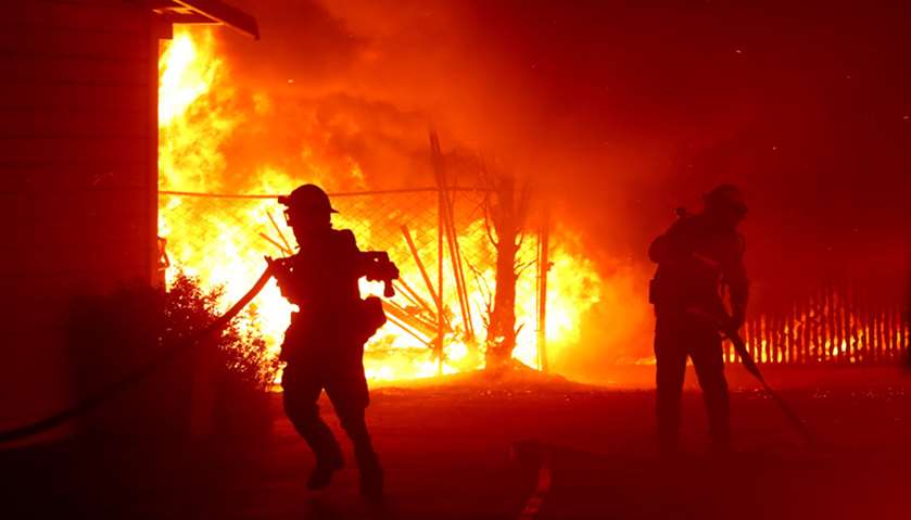 Firefighters battle the Kincade Fire as it burns a barn in California