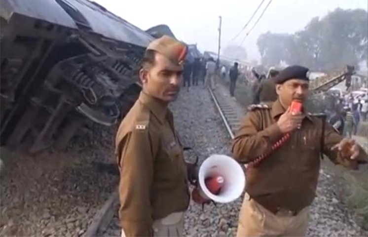 A police officer instructs people and rescuers at the site of the train crash
