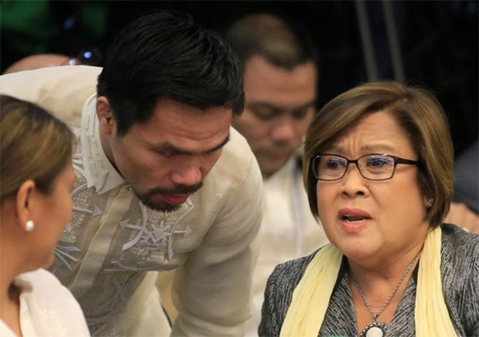 Filipino boxer and Senator Manny Pacquiao talks to fellow Senator Leila De Lima during the hearing