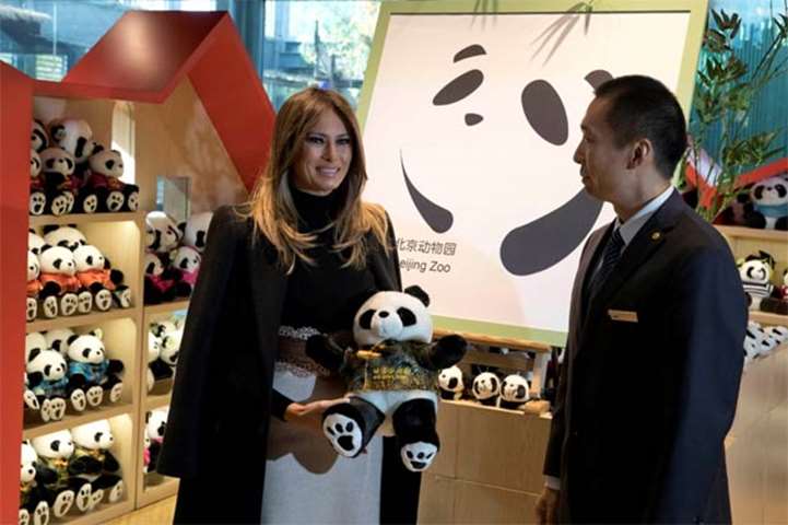 Melania Trump poses with a panda plushie after visiting the panda enclosure at the Beijing Zoo