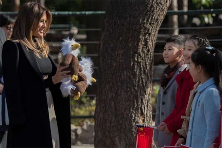 Melania Trump offers stuffed toy eagles, from the US, to children at the Beijing Zoo