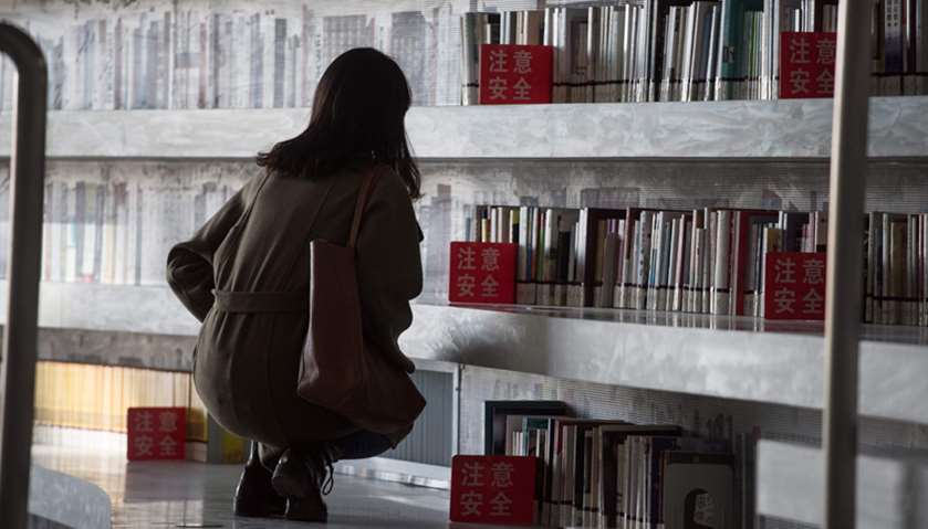 A woman looking at books at the Tianjin Binhai Library