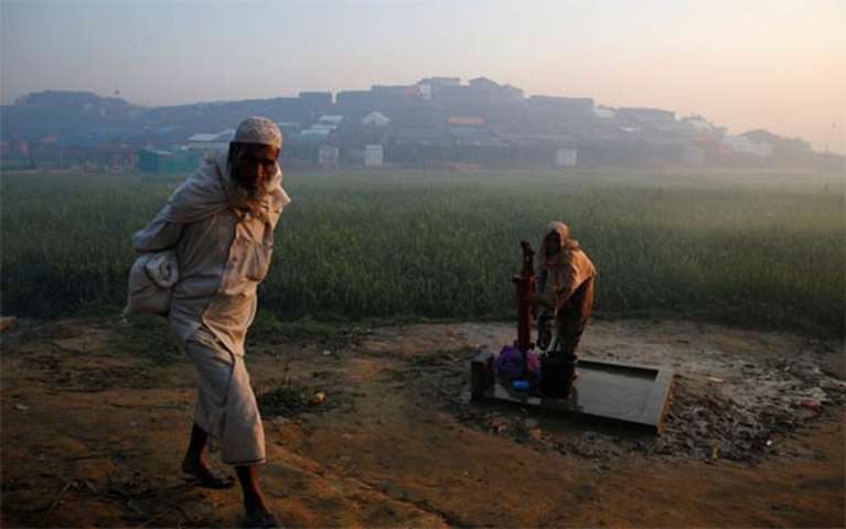 A Rohingya refugee extracts water from a tube well at Palongkhali refugee camp