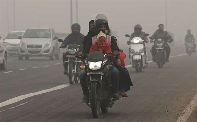People commute on a smoggy morning in New Delhi on Wednesday