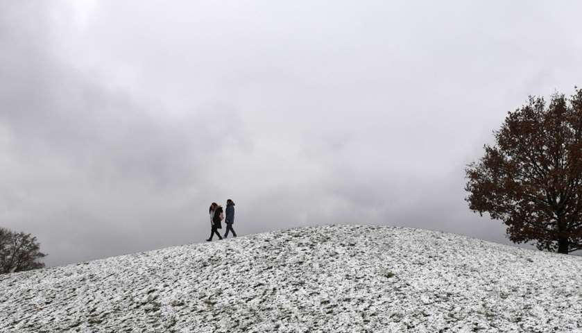People walk through the snow-covered Olympic park in Munich, southern Germany
