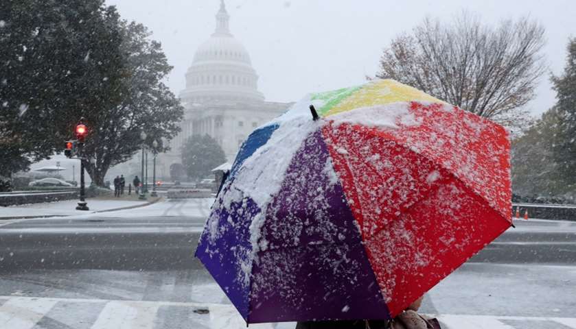 A woman walks in a light snow near the U.S. Capitol in Washington, US