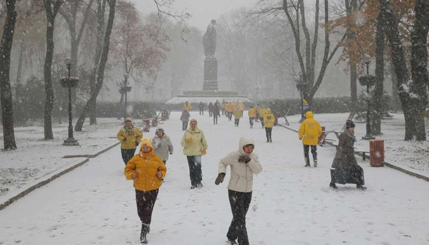 People exercise at a park amid a snow flurry in central Kiev, Ukraine
