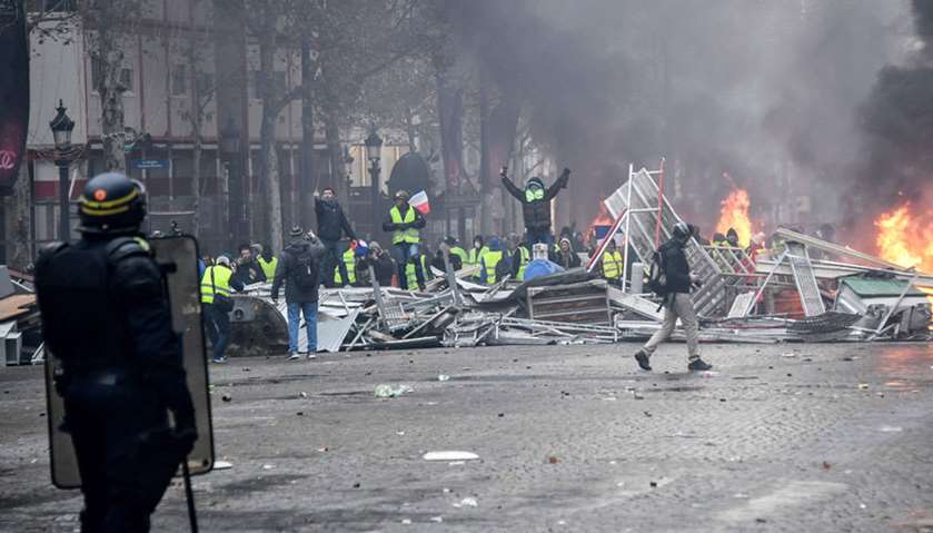 Yellow vests (Gilet jaune) protestors shout slogans at riot police near the Place de la Concorde in 