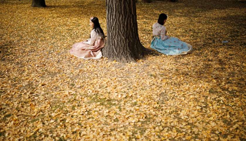 Women pose for photographs at Gyeongbok Palace
