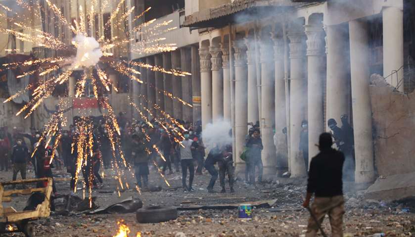 Iraqi demonstrators throw fireworks towards Iraqi security forces during the ongoing anti-government
