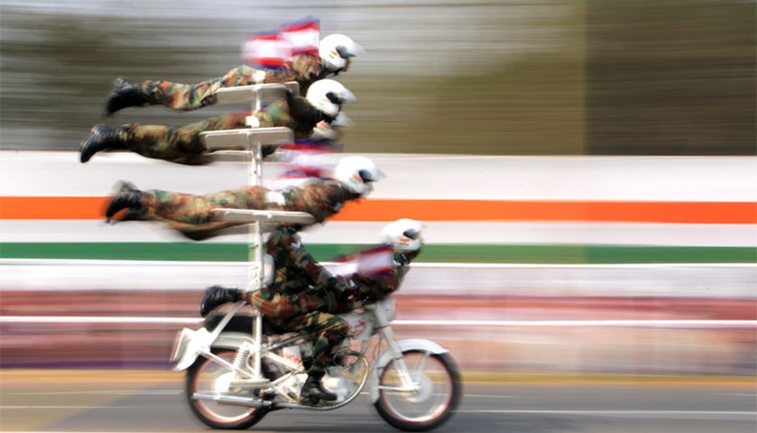 Indian military personnel perform on a motorbike during the parade