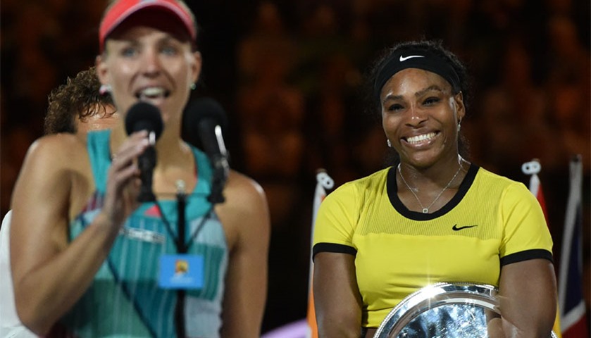Angelique Kerber (L) is watched by Serena Williams as she addresses the crowd