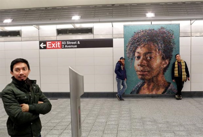 People check out a tile mosaic by Chuck Close decorating the 86th St. Q train station
