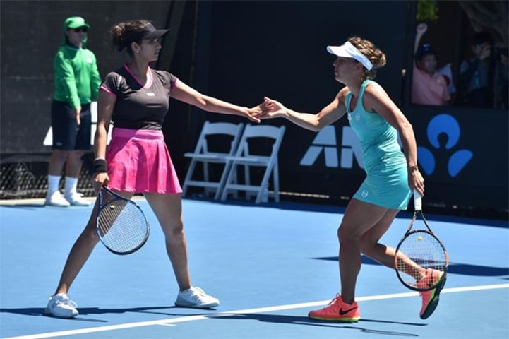 India\'s Sania Mirza gestures with Czech Republic\'s Barbora Strycova during their women\'s doubles