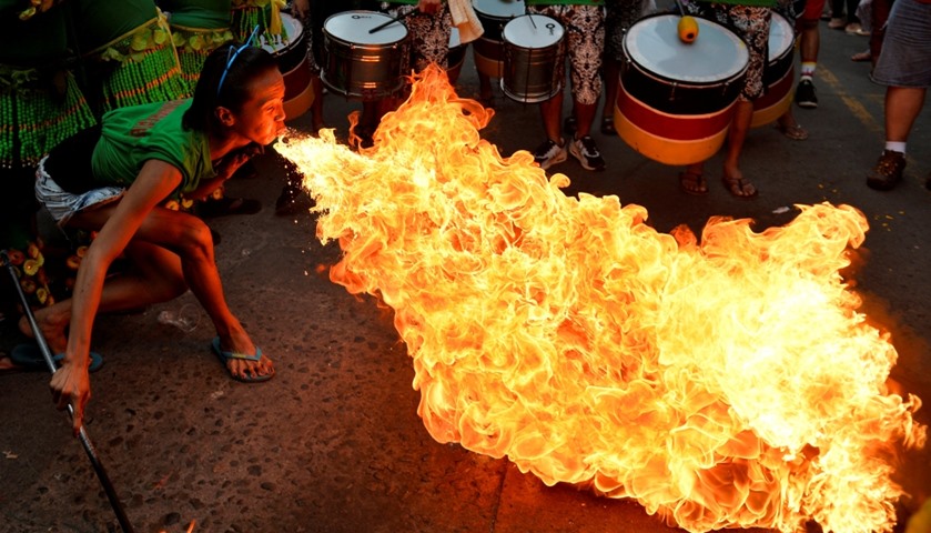 A reveller blows fire during the celebrations