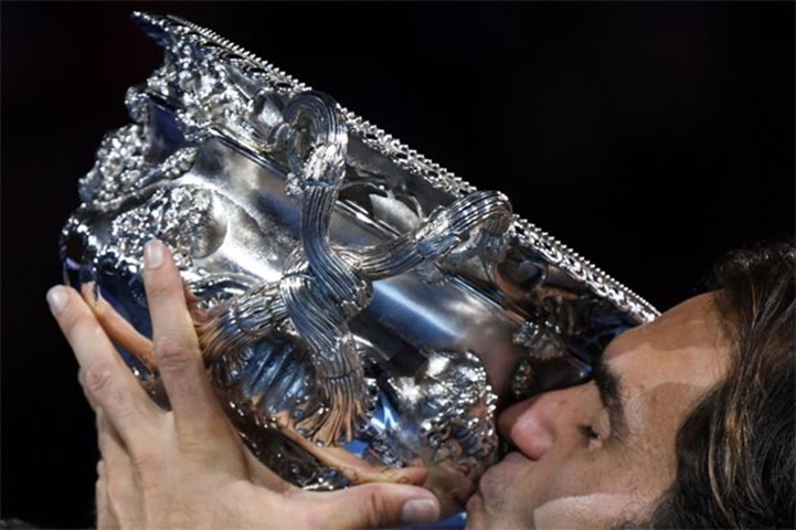 Roger Federer kisses the trophy after his success at the Australian Open
